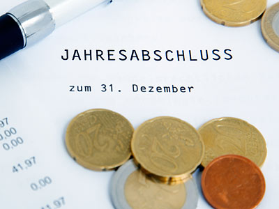 Ein Dokument mit der Überschrift "Jahresabschluss" und einigen Münzen.