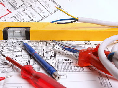 Werkzeuge und elektrische Leitungen auf einem Architekturplan.
